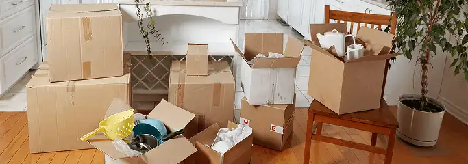 Packed moving boxes and household items in a kitchen before move-out or move-in cleaning, Cambridge, MA.